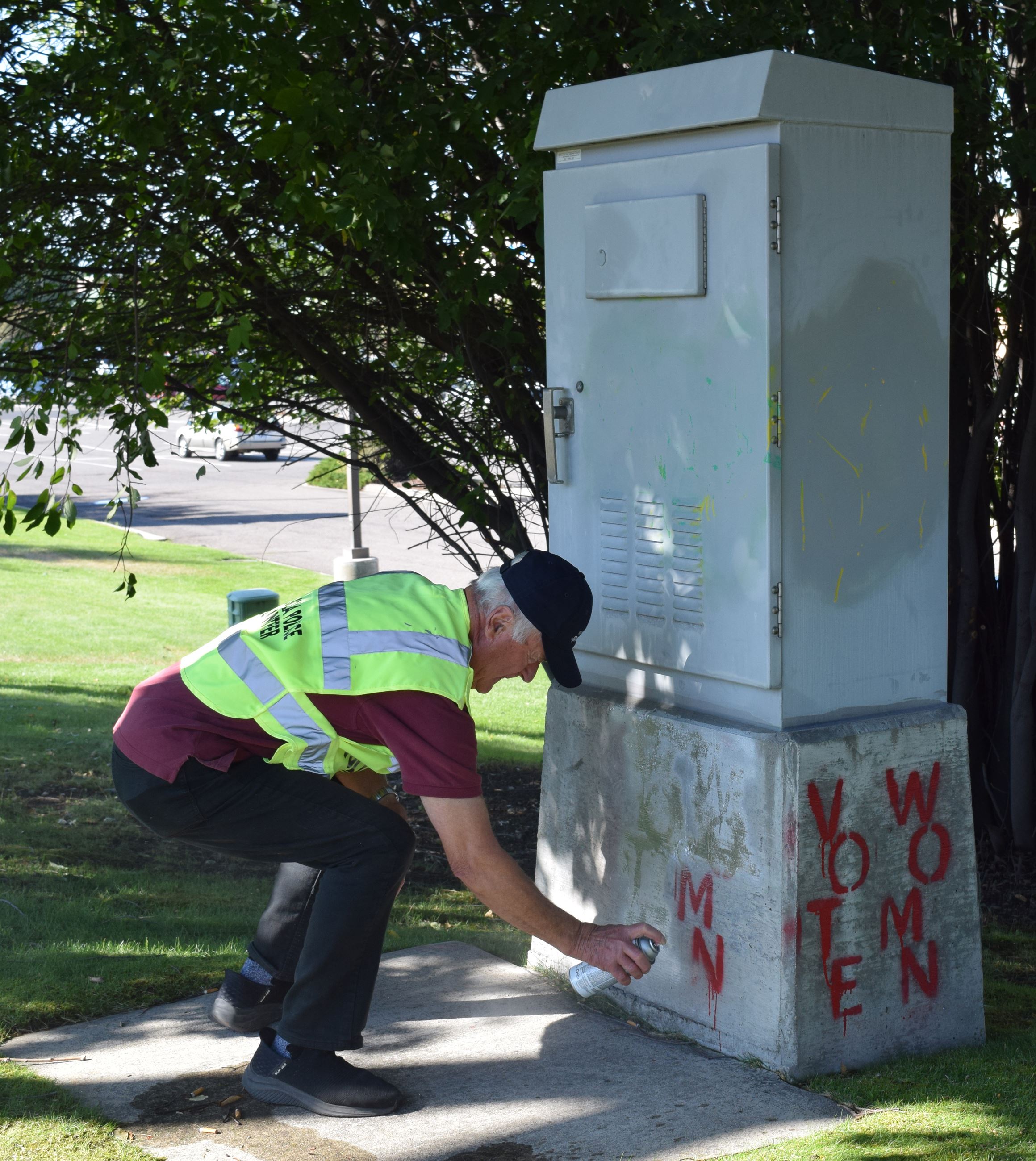 Volunteer covering graffiti